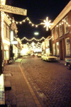 001 Grotestraat bij avond met kerstverlichting/kerstversiering rechts de Familie Luessenstichting. Links aan het pand ...