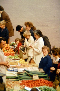 0639 Groenteboer Jansen uit Zevenaar op de zaterdagochtenmarkt. De schrijvende vrouw heet Waals-van Wijk en de vrouw ...