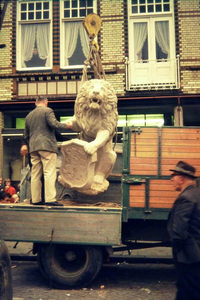 0744 De nieuwe leeuw hangt in de takels om op zijn plaats te worden gebracht. Op de wagen Jan Gunnewick en op straat ...