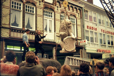 0745 Beeldhouwer Elbert uit Bocholt geeft met handgebaren aan hoe de leeuw gevierd moet worden om hem goed op de sokkel ...