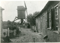 1095-32-005 Stender-molen uit de 16e eeuw. Links de woning van Straks (vader Straks schildert het tuinhek). Het tweede ...