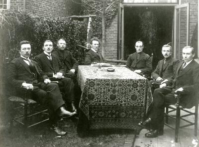 002 Kerkenraad, waarschijnlijk vergaderend in de tuin van drukker-boekhandelaar H. Heinen. Van links naar rechts: ...