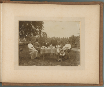 283-0022 Mensen zitten aan een tafel in een tuin, 1905-1910