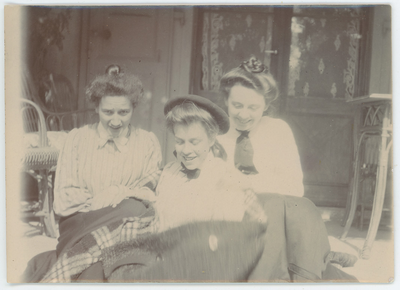 112-0023 Drie meisjes in gestreepte blouses buiten onder een deken op een veranda , 1880-1940