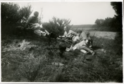 14-0211 Henriëtte ligt met twee onbekende mensen tegen een helling, 1927