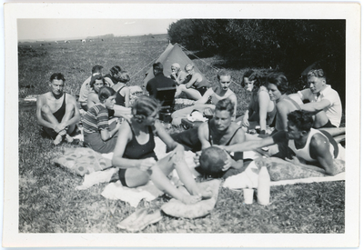 46 Jongeren in zwem- en sportkleding, etend bij een tentje, 1933