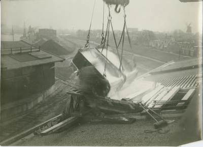 2160 Delfzijl (haven) : Leegstorten van bakken chilisalpeter boven een in de luiken van het dak van ..., 1930