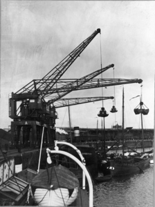 2212 Delfzijl (haven) : Nieuwe wipkranen staan op de kade en lossen steenkool, 1934