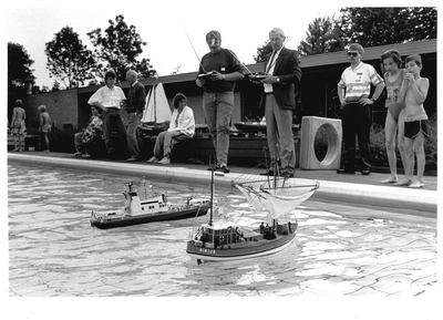 GAV-F-W-1471 Twee heren demonstreren radiografisch bestuurbare modelboten in zwembad De Schaeck aan de Veenhuisweg in ...