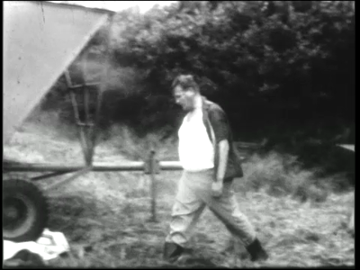 9962BB00410 0:00:002 mannen oogsten met een combine en laden vervolgens de oogst op een platte wagen. ...