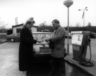 73961 Afbeelding van een pompbediende tijdens het afrekenen met een klant op het benzinestation van het warenhuis ...