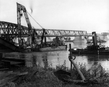 157341 Gezicht op de hertsellingswerkzaamheden (bouw van een tijdelijke noodbrug) aan de spoorbrug over de Waal bij ...