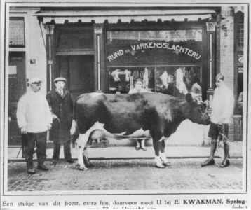 70558 Afbeelding van de slager E. Kwakman met zijn personeel en een koe voor de etalage van zijn Rund- en ...
