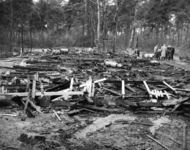 125259 Gezicht op de restanten van het door brand verwoeste kamphuis van de Stichting Recreatiecentrum het Grote Bos te ...