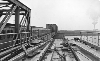 155302 Gezicht op de spoorbrug over de Beneden Merwede bij Baanhoek met een diesel-electrisch treinstel DE 3 (Plan U) ...