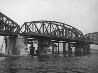 157319 Afbeelding van de herstellingswerkzaamheden aan de spoorbrug over de Waal te Nijmegen. Het laatste nood-brugdeel ...