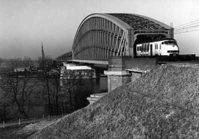 153671 Gezicht op de spoorbrug over de Lek bij Culemborg met een electrisch treinstel plan V (mat. 1964) van de N.S.