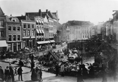 123908 Gezicht op de Oudegracht te Utrecht met op de voorgrond de pottenmarkt op de Bakkerbrug en op de achtergrond het ...