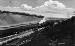 161417 Gezicht in de ingraving van de spoorlijn te Nijverdal, met een passerende trein getrokken door een ...