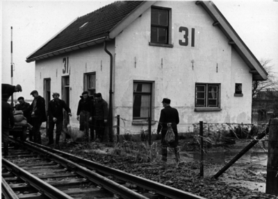 157040 Afbeelding van het lossen van zandzakken bij de spoorlijn te Kruiningen, ter hoogte van wachtpost 31, na de ...