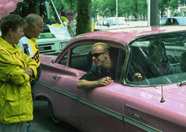 120327 Afbeelding van enkele deelnemers aan de stoet door de binnenstad van Utrecht, in een roze Chevrolet Bel Air op ...