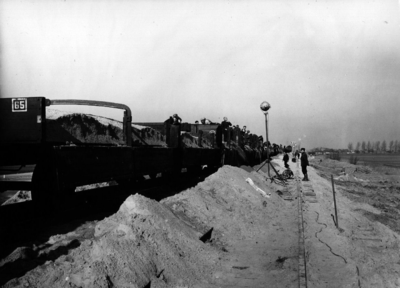 157042 Afbeelding van het lossen van zand voor zandzakken op de spoorlijn bij Rilland-Bath, na de watersnoodramp.