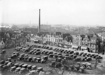 62265 Gezicht op een gedeelte van het parkeerterrein met op de achtergrond de voorgevels van enkele huizen aan de ...