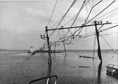 152839 Afbeelding van de overstroomde spoorlijn bij Lage Zwaluwe kort na de watersnoodramp. Op de achtergrond het ...