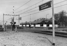 150398 Gezicht op de overweg en het N.S.-station Heerenveen-IJsstadion met de hallen van Europa Meubel te Heerenveen.