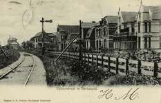 165077 Gezicht op de spoorlijn van de N.C.S. langs de Spoorstraat te Barneveld, met links op de achtergrond het ...