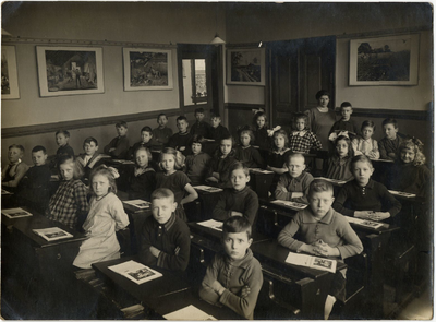 128222 Groepsportret van de kinderen in een klas met mej. I. Poortermans in, vermoedelijk, de Openbare Lagere School ...