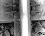 166476 Detail van een spoorstaaf met klemveer op een betonnen dwarsligger.