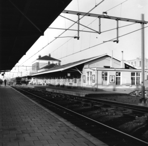 166761 Gezicht op de perronzijde van het N.S.-station Heerenveen te Heerenveen, met op de voorgrond de goederenloods.