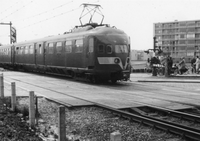 101527 Afbeelding van een electrisch treinstel mat. 1936 van de N.S. op de spoorwegovergang in de Mr. Tripkade / ...