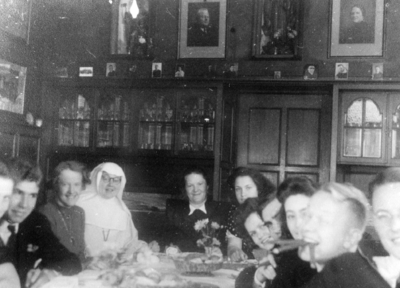 129710 Afbeelding van de familie Jongerius rond de tafel in de woonkamer van het woonhuis (Nieuwe Bastiaanshof) ...