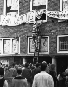 103335 Afbeelding van een kraker die via een ladder het kraakpand Drift 13 te Utrecht tracht te verlaten, tijdens de ...