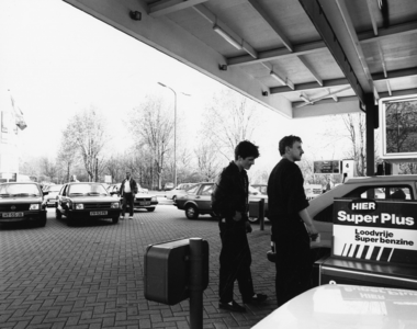 103485 Afbeelding van het voltanken van een juist verworven auto voor de reis naar Oost-Europa bij het benzinestation ...