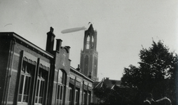 600385 Afbeelding van het luchtschip Graf Zeppelin boven Utrecht, met op de voorgrond een deel van de R.K. school ...