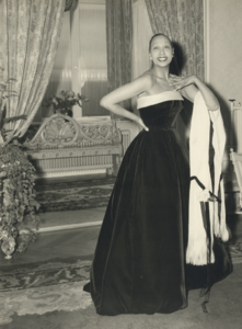 827572 Portret van de Amerikaans-Franse cabaretière Josephine Baker (1906-1975) tijdens het passen van een avondjapon ( ...