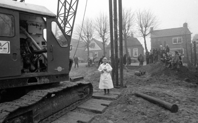 RJ000001129 Warder.Mevrouw T. Kout- Doets staat vol trots klaar om de eerste paal te slaan voor het nieuwe kruisgebouw ...