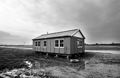 RJ000000862 Een bouwkeet staat op het lege terrein van uitbreidingsplan Neck Noord. (NNC 22-10-1976)