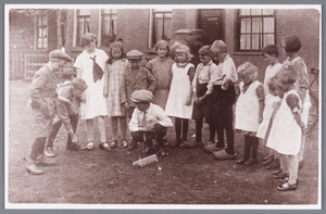 WAT002000649 We zien hier een groep kinderen aan het knikkeren.