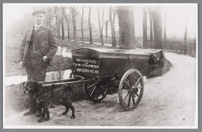 WAT002000790 Willem Hartog (1886) met hondenkar met manufacturen lopend in Krommeniedijk bij café Aukes (Tolhuis).