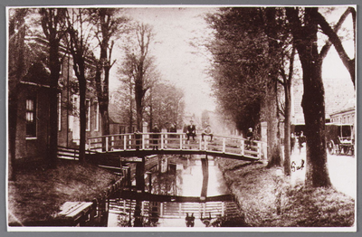 WAT002001546 Links het Gemeentehuis / raadhuis met brug over wegsloot. Rechts vooraan als kind Piet Vink (1892) en ...
