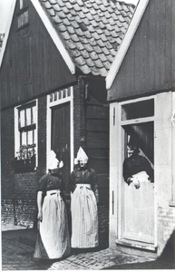 WAT006004244 Visserstraat in Volendam. Nu de begraafplaats van de Vincentiuskerk. In de deuropening: Geertje Steur (van ...