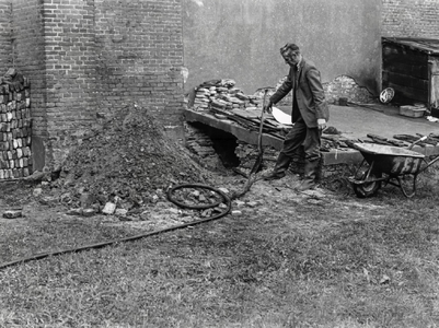 )VI-00001834 Bij het openen van de oude grafkelder tegen de noordmuur van de NHkerk. Voorzitter N.de Boer van de ...