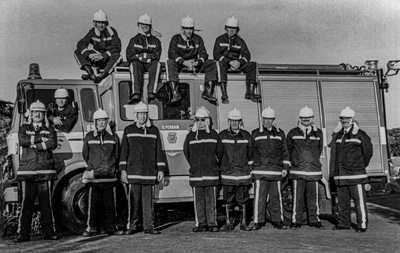OVI-00002002 Het vrijwillige brandweercorps poseert in uniform op en naast de wagen