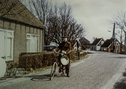 OVI-00002025 de dorpsomroeper G.v.d.Meer met gong op de fiets bij zijn ronde Monn.rijweg bij nr 39