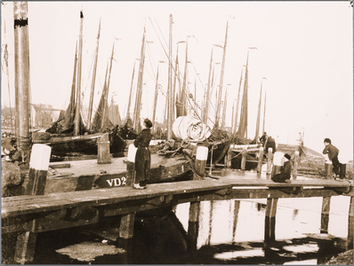 WAT001019790 De haven van Volendam met botters en vissers aan het werk.