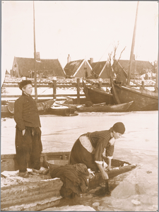 WAT001019795 De was doen in een ijswak langs de kant van de haven.